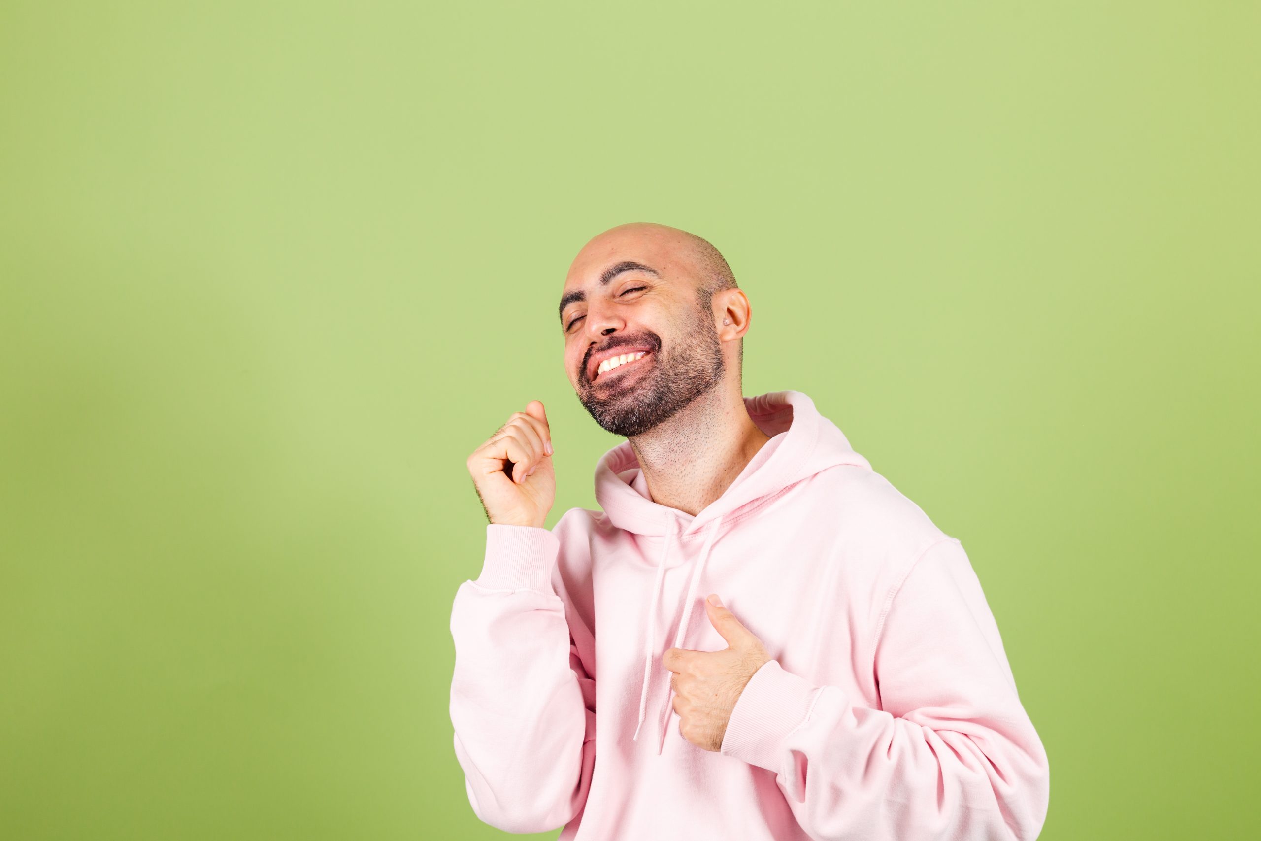 young bald caucasian man pink hoodie isolated happy cheerful smiling moving casual confident listening music scaled